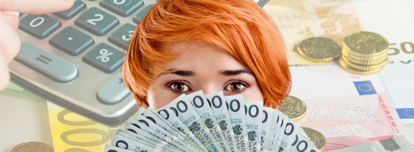 Woman holding bank notes close to her face with a calculator and bills in the background / Frau hält Banknoten an ihr Gesicht mit Taschenrechner und Rechnungen im Hintergrund